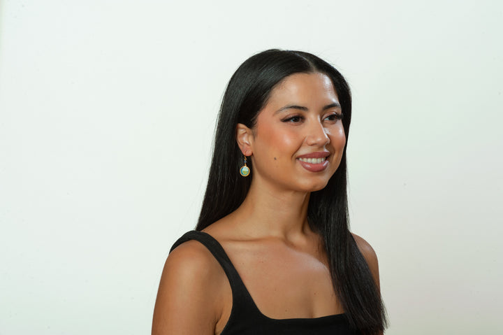 Woman with long dark hair wearing a black top against a white background