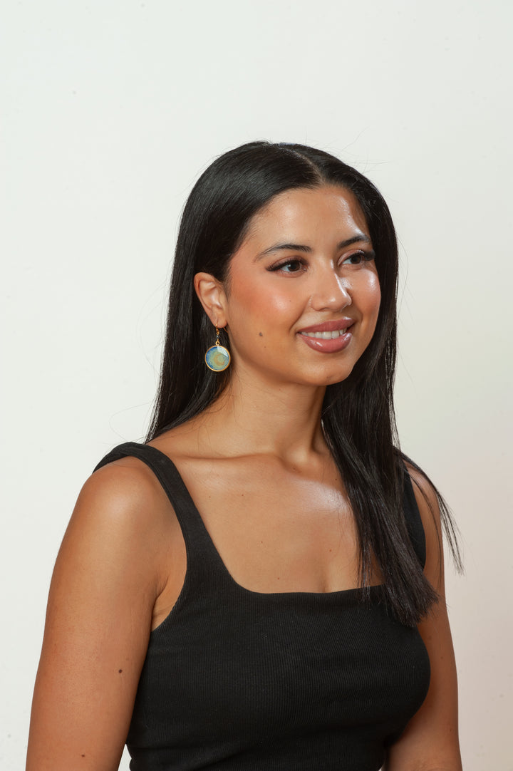 Woman wearing a black sleeveless top against a plain background