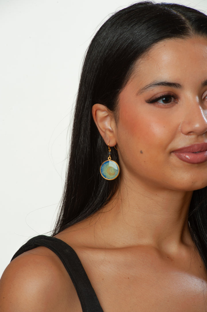 Close-up of a woman wearing a round earring with a white background