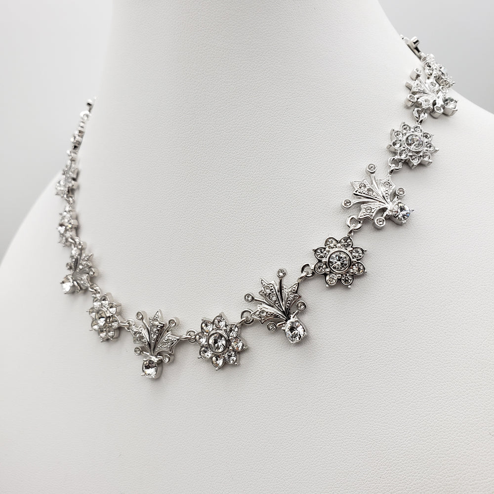 Silver floral bracelet on a white stand