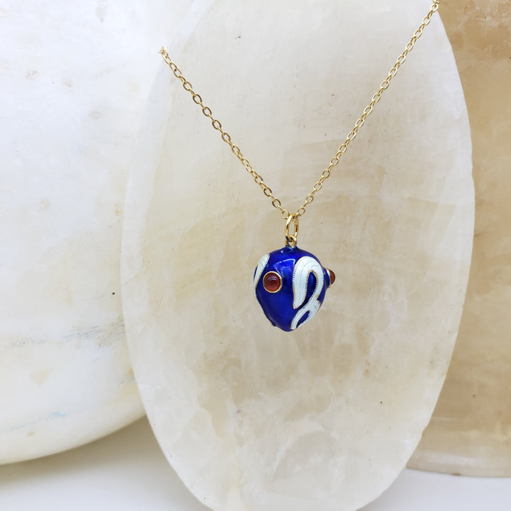 Necklace with a blue and white pendant on a beige stone background