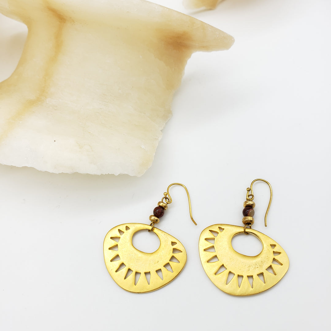 Gold earrings with a geometric design on a white background