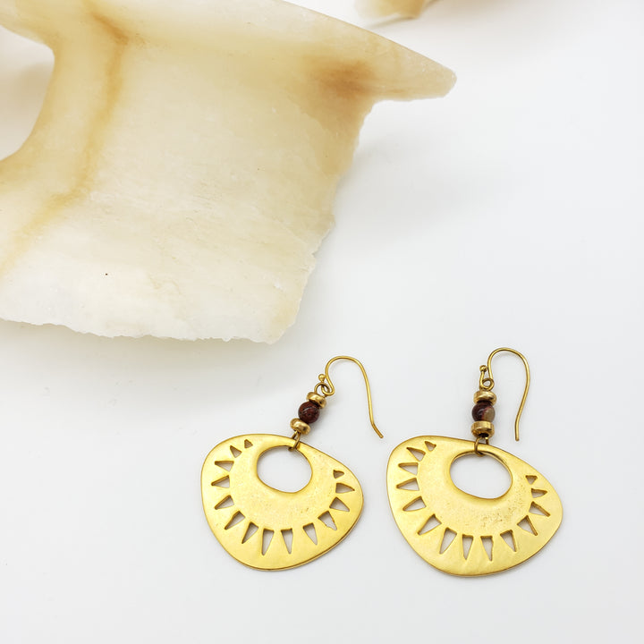 Gold earrings with a geometric design on a white background