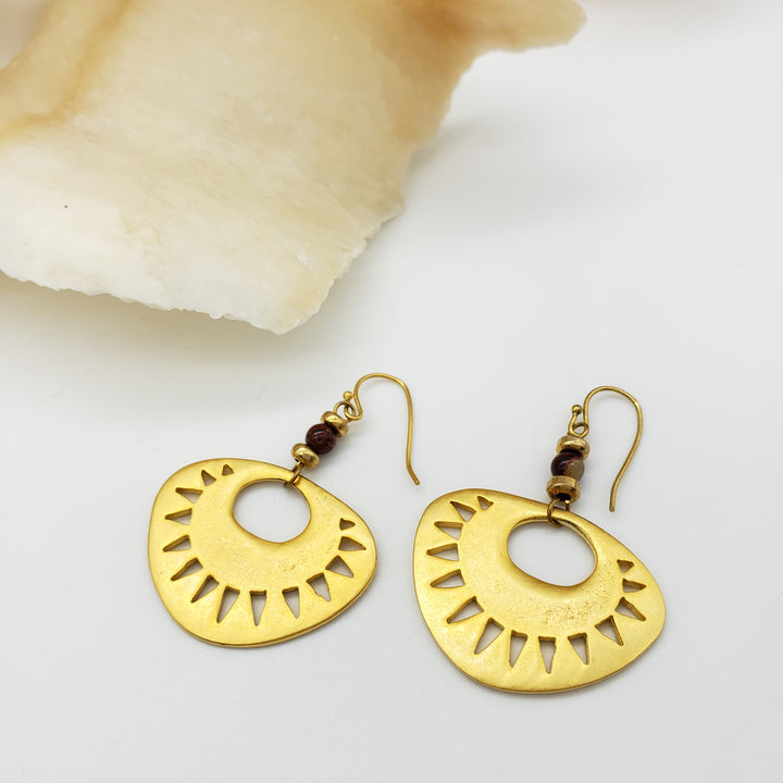 Gold hoop earrings with cut-out design on a white background
