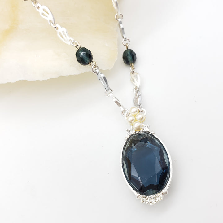 Necklace with a blue gemstone on a white background