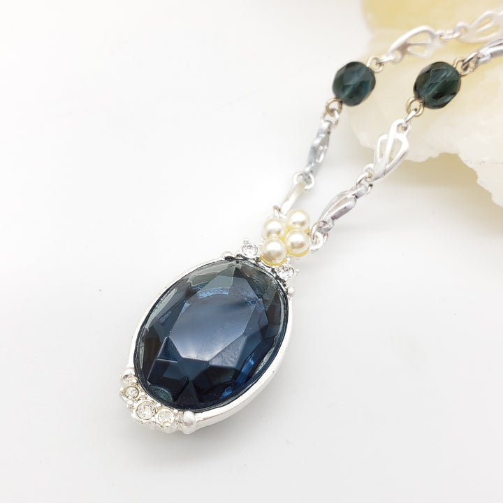 Necklace with a blue teardrop pendant on a white background