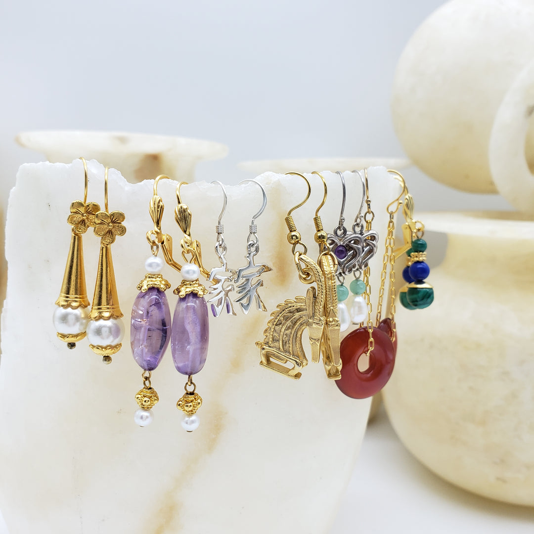 Collection of earrings on a white stone surface