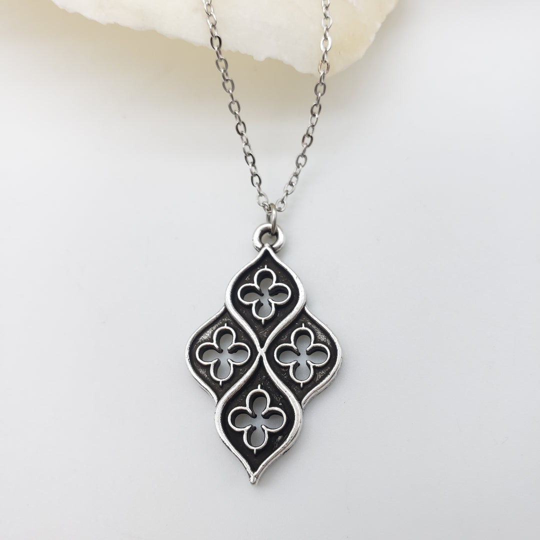 Silver necklace with a decorative pendant on a white background