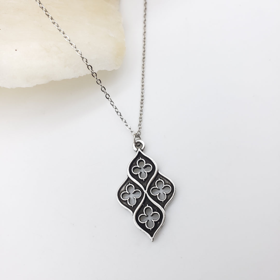 Silver necklace with a floral pendant on a white background