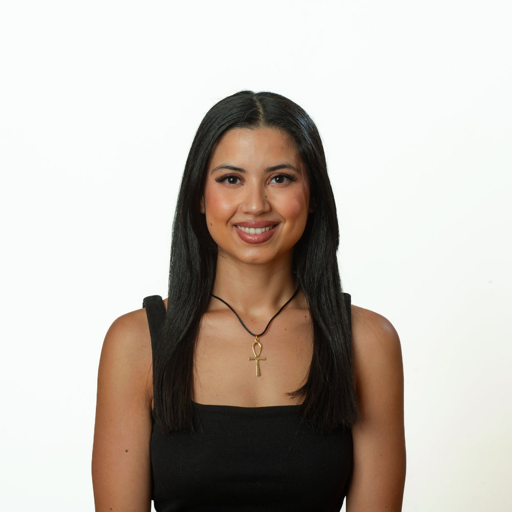 Woman with long dark hair wearing a black top on a white background