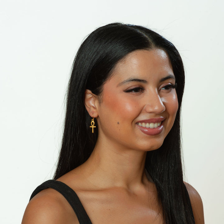 Woman with long dark hair wearing a black top against a white background