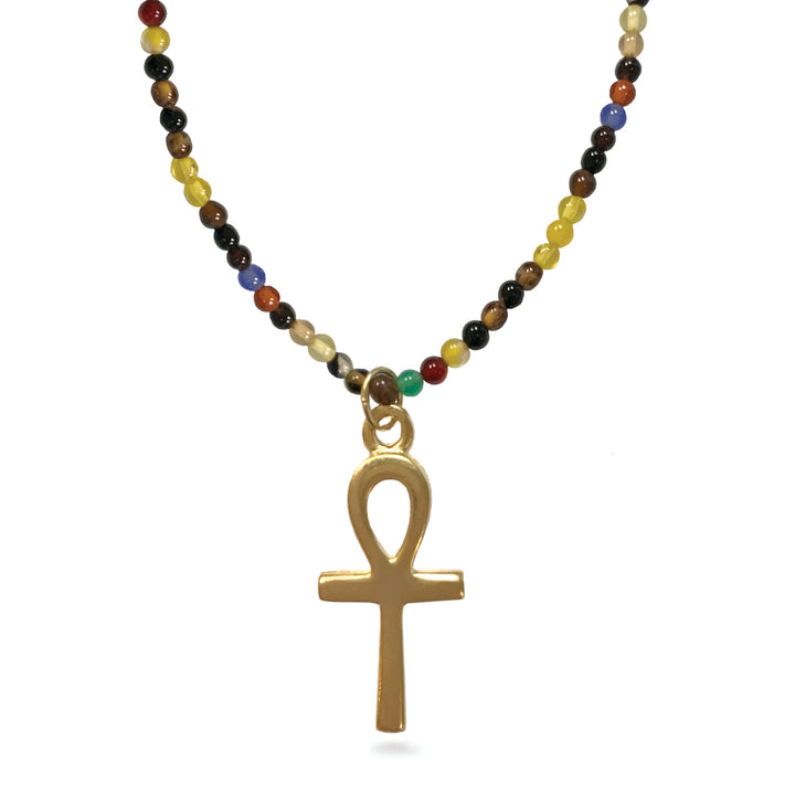 A gold-plated Ankh pendant necklace on a beaded chain. The chain features small, round beads in multiple colors including yellow, brown, black, red, blue, and green, set against a plain white background.