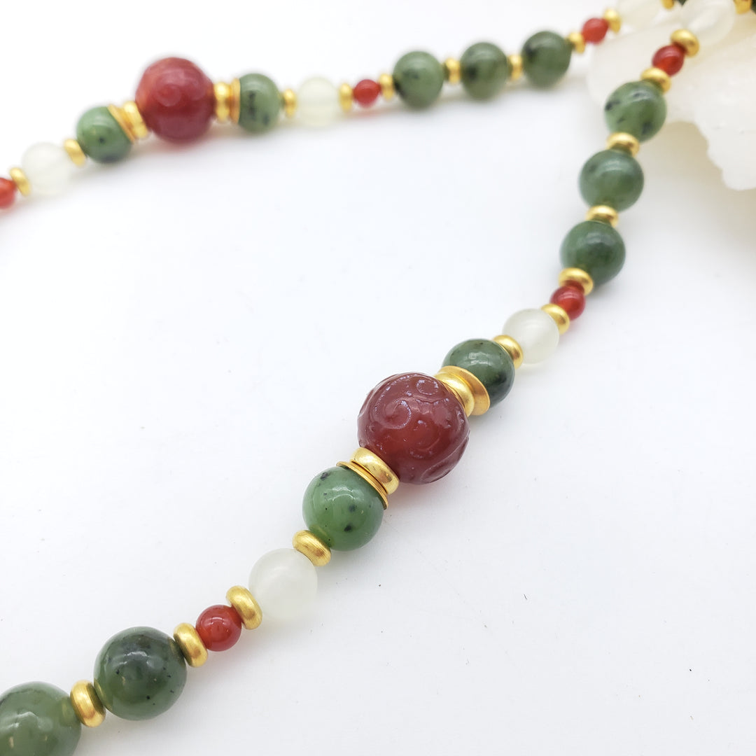 Necklace with green, red, and white beads on a white background