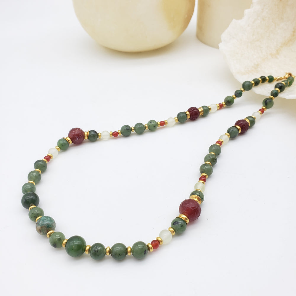 Necklace with green and red beads on a white background