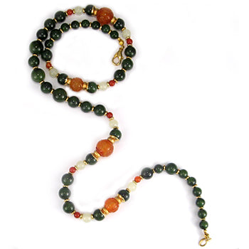 Beaded necklace with green, orange, and white beads on a white background