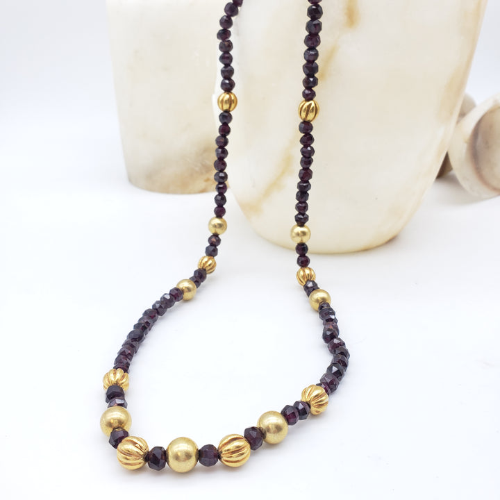 Necklace with red and gold beads on a white background