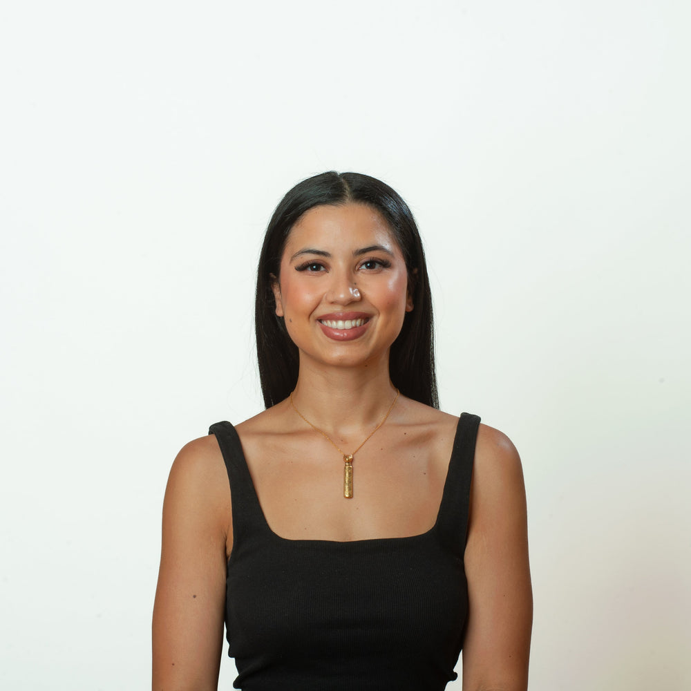 Woman wearing a black tank top against a white background