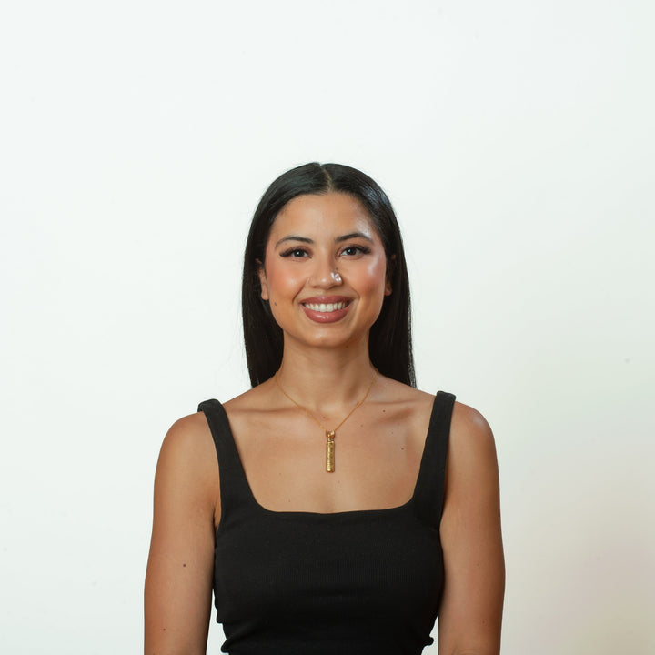 Woman wearing a black tank top against a white background