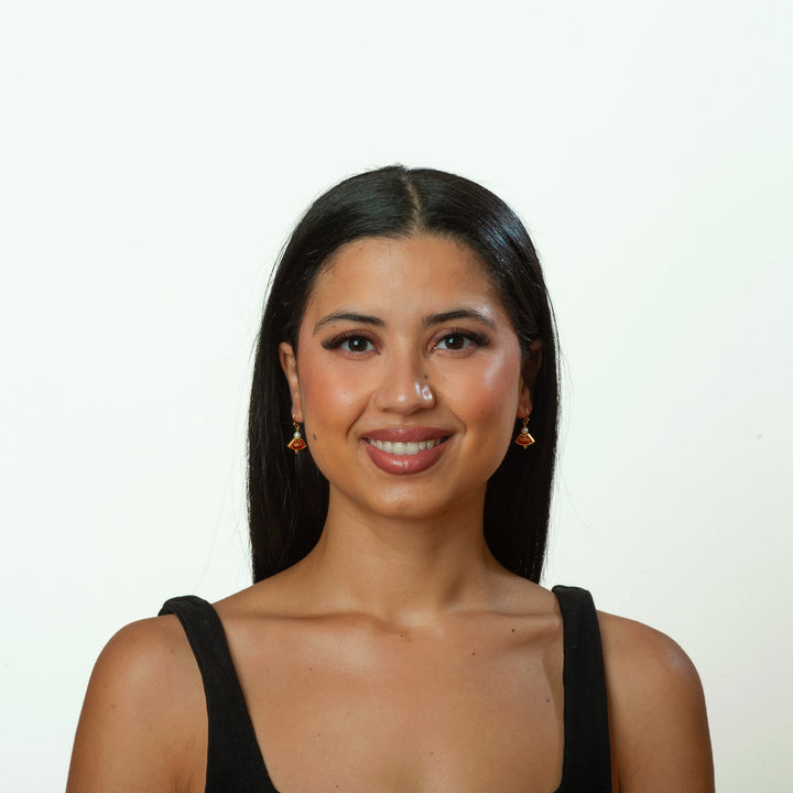 Woman with long dark hair wearing a black top against a white background