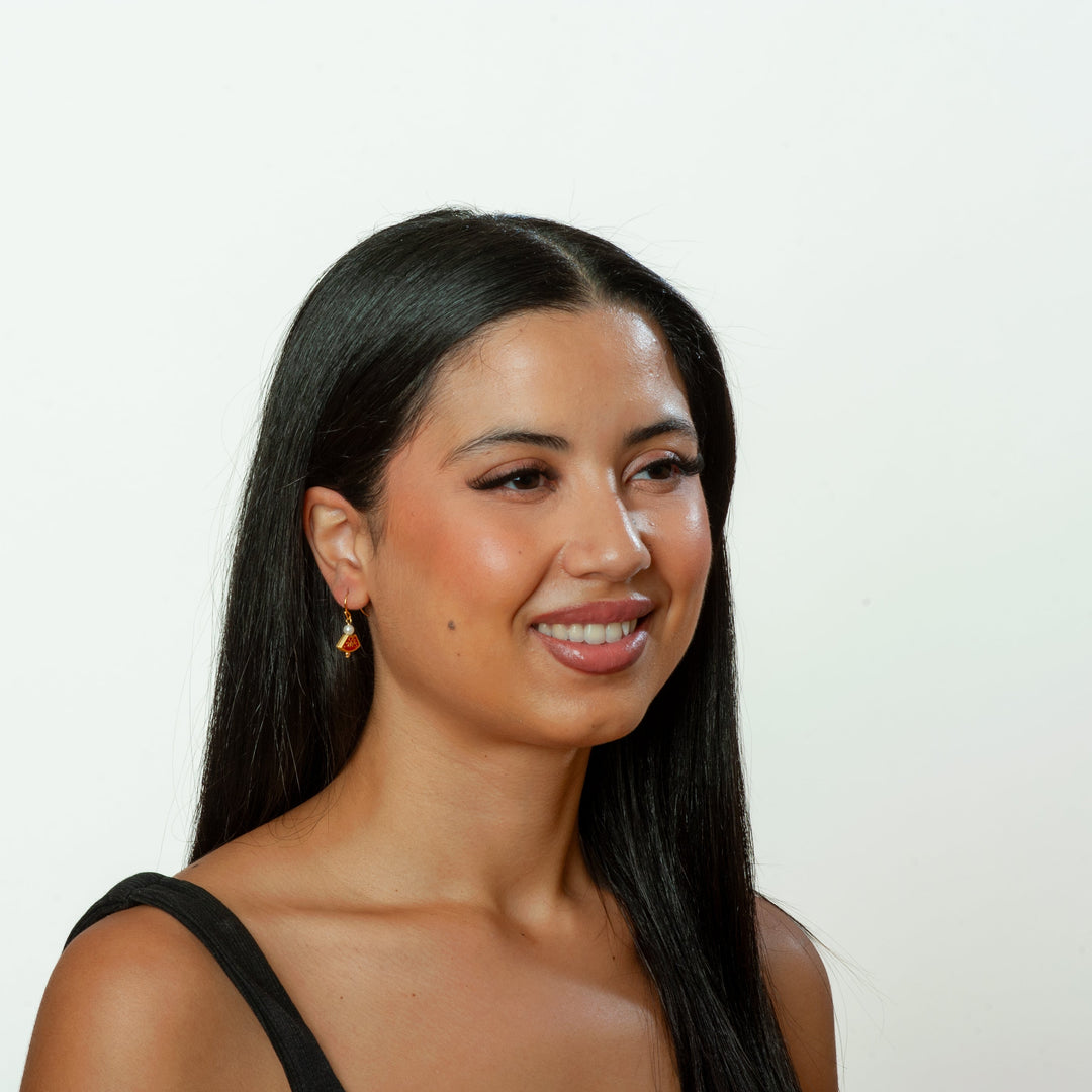 Woman with long dark hair smiling against a plain background