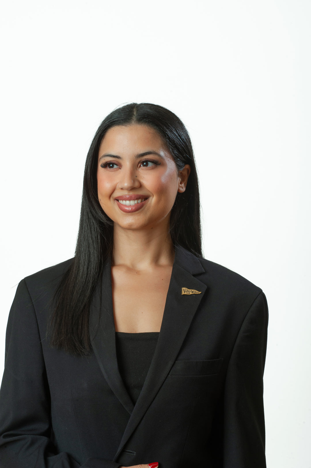 Woman wearing a black blazer with a visible logo on a white background
