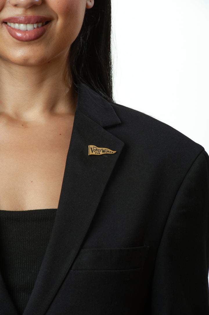 Black blazer with a visible brand logo worn by a person on a white background