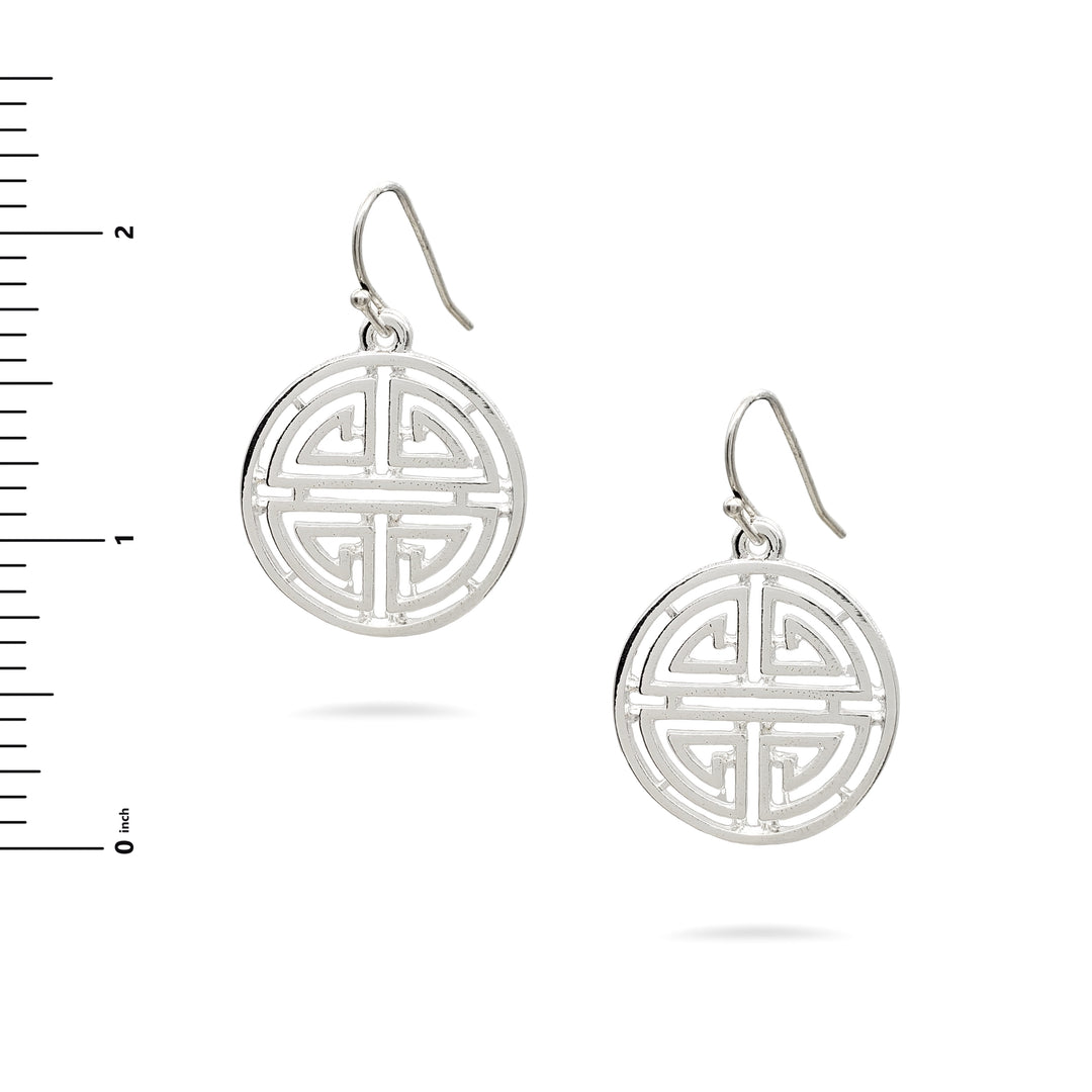 Silver earrings with intricate design on a white background with a ruler for scale.