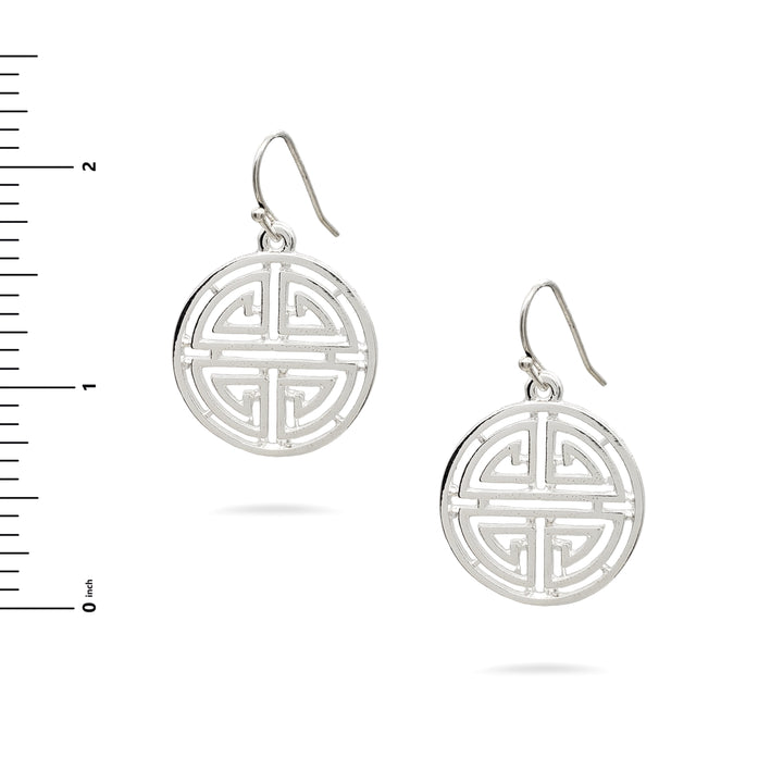Silver earrings with intricate design on a white background with a ruler for scale.