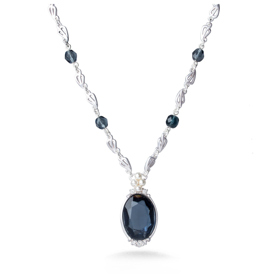 Silver necklace with dark blue gemstones on a white background
