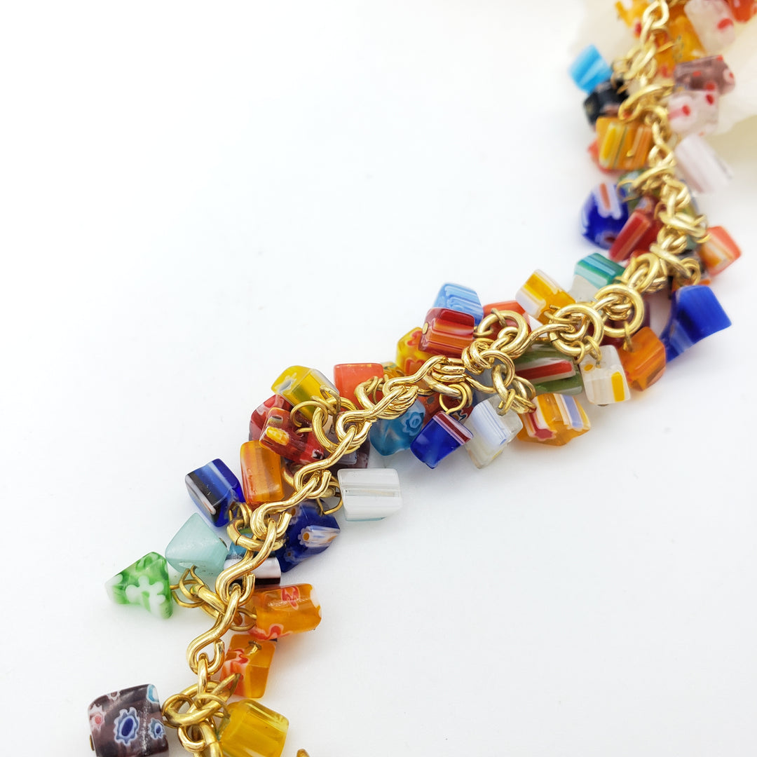 Colorful beaded necklace with gold chain on a white background